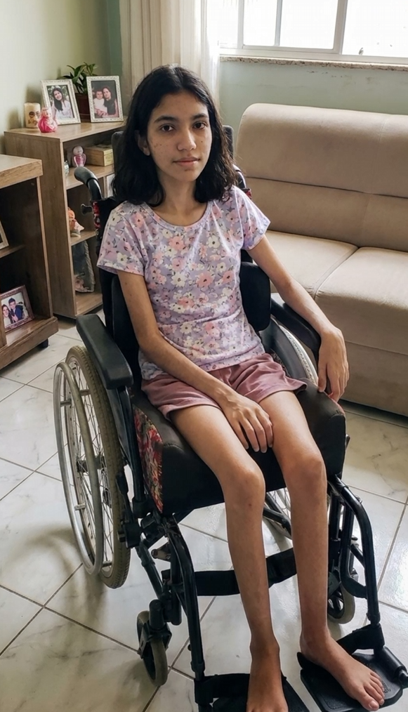 Isadora na cadeira de rodas, em casa, lutando para ter a chance de caminhar